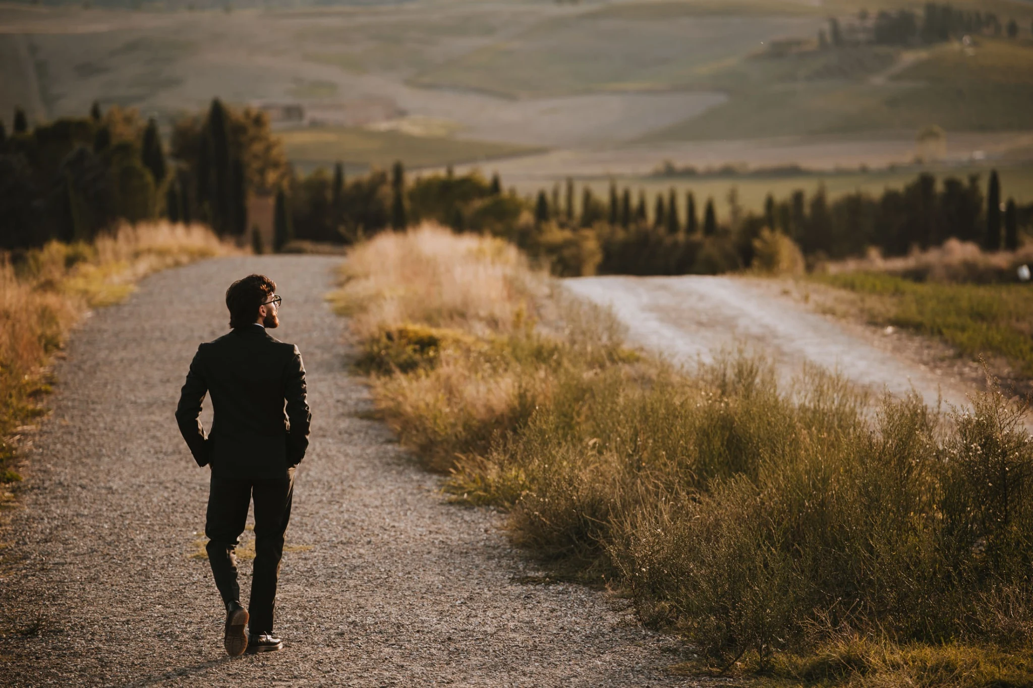 Lo sposo percorre il sentiero tra le colline al tramonto