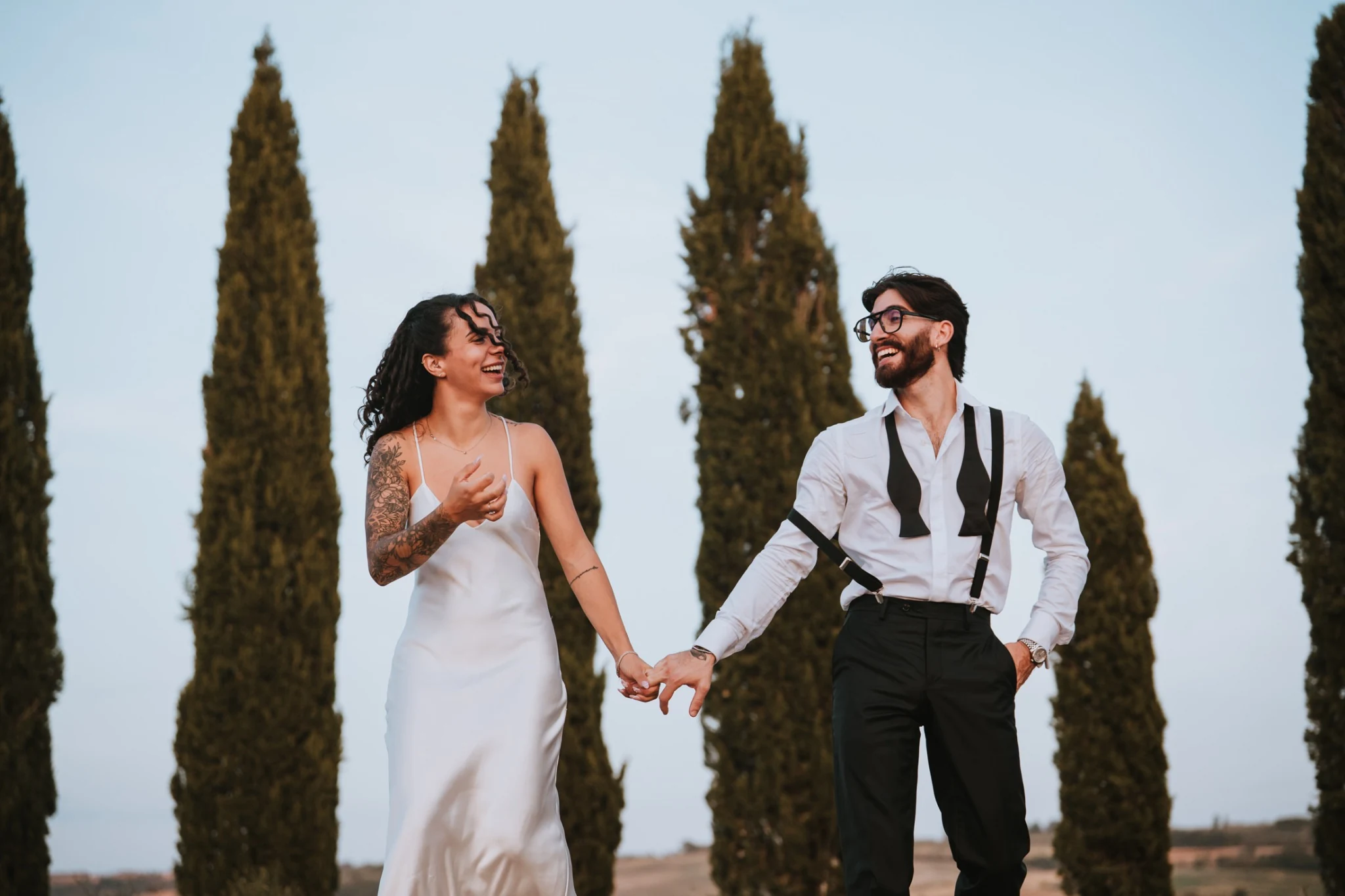 Gli sposi sorridono tra i cipressi
