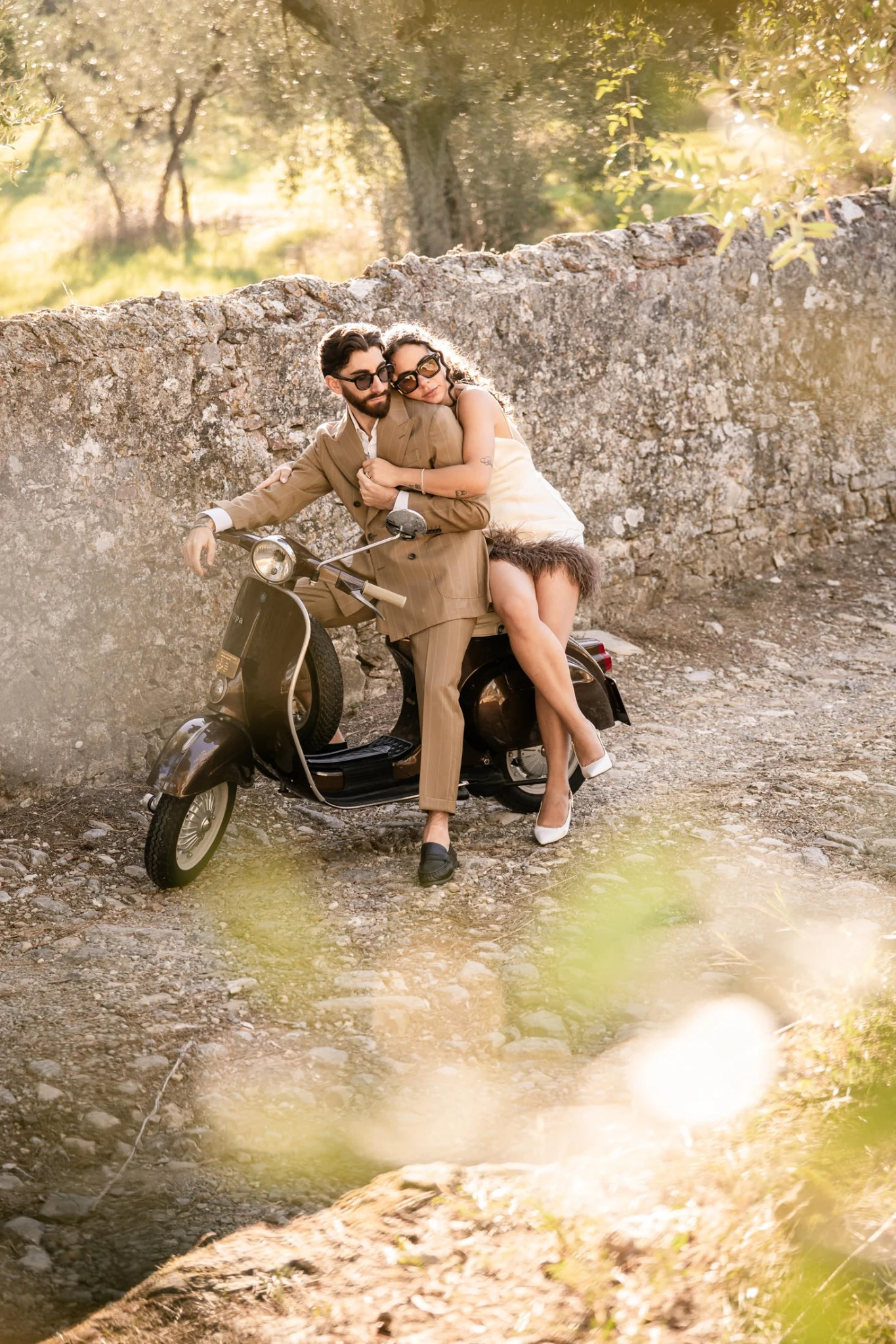 Gli sposi in Vespa su una strada di campagna