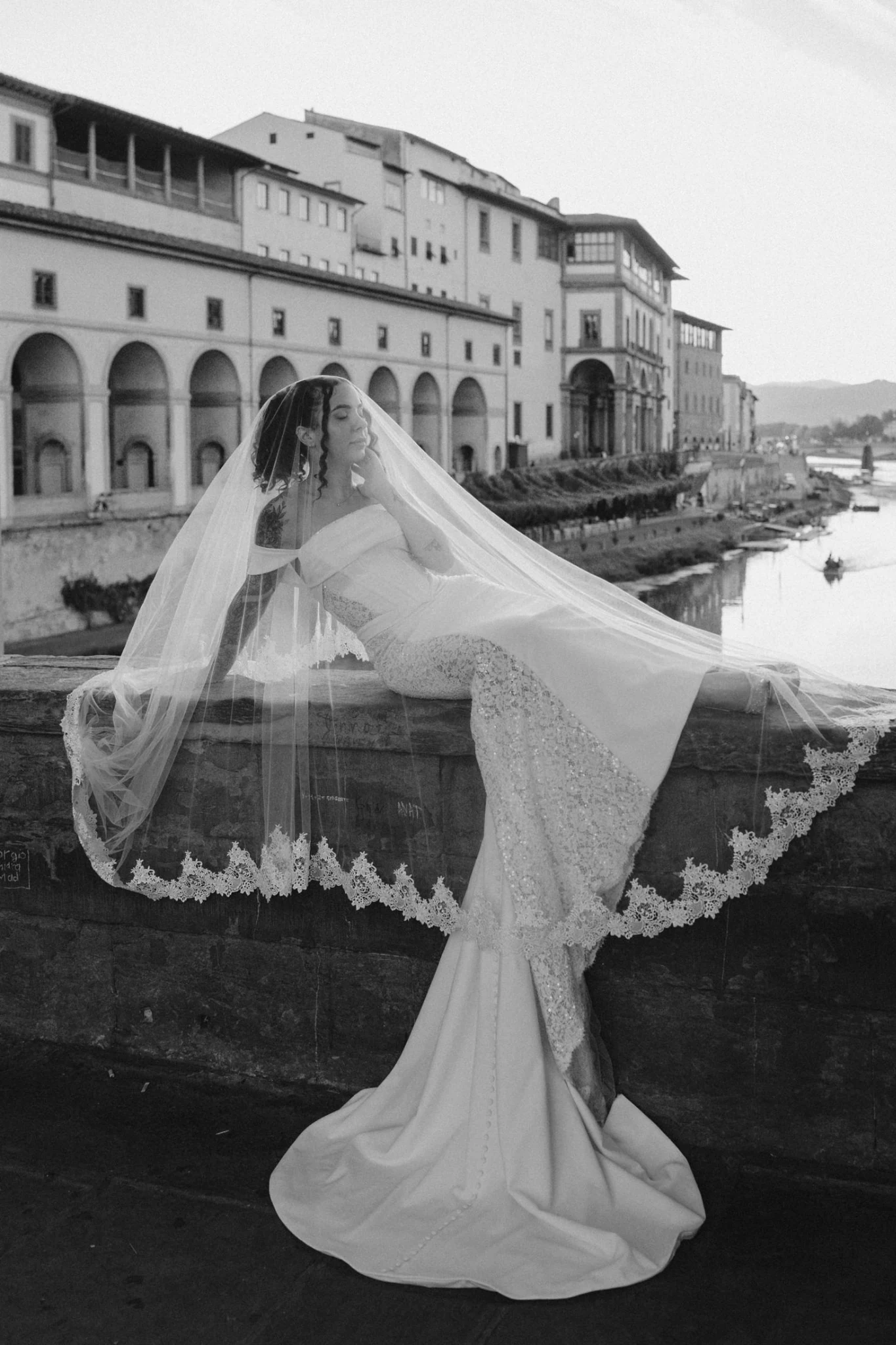 La sposa fa volteggiare il velo sul ponte, in bianco e nero
