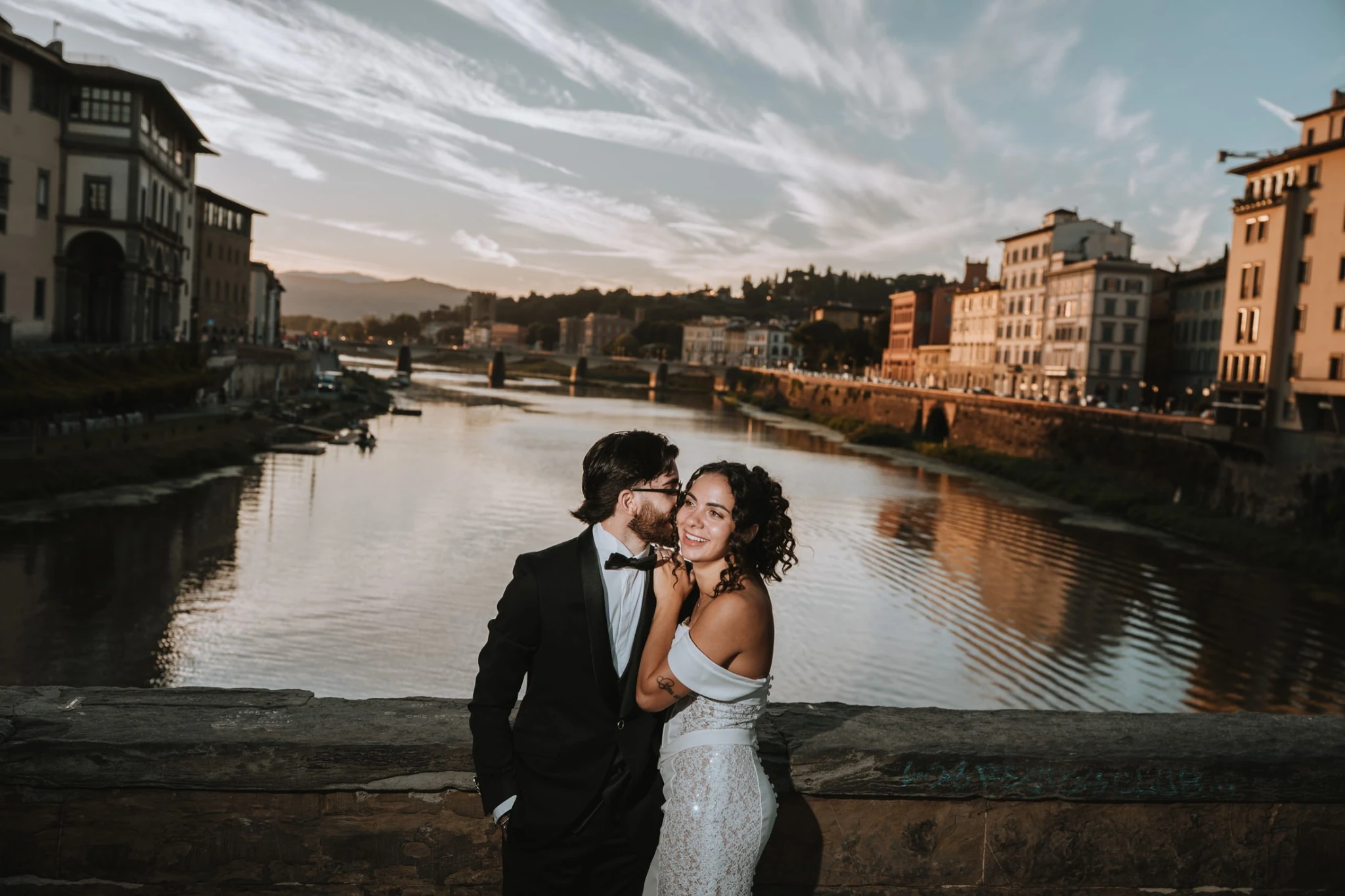 Un bacio sul ponte davanti al paesaggio dell’Arno