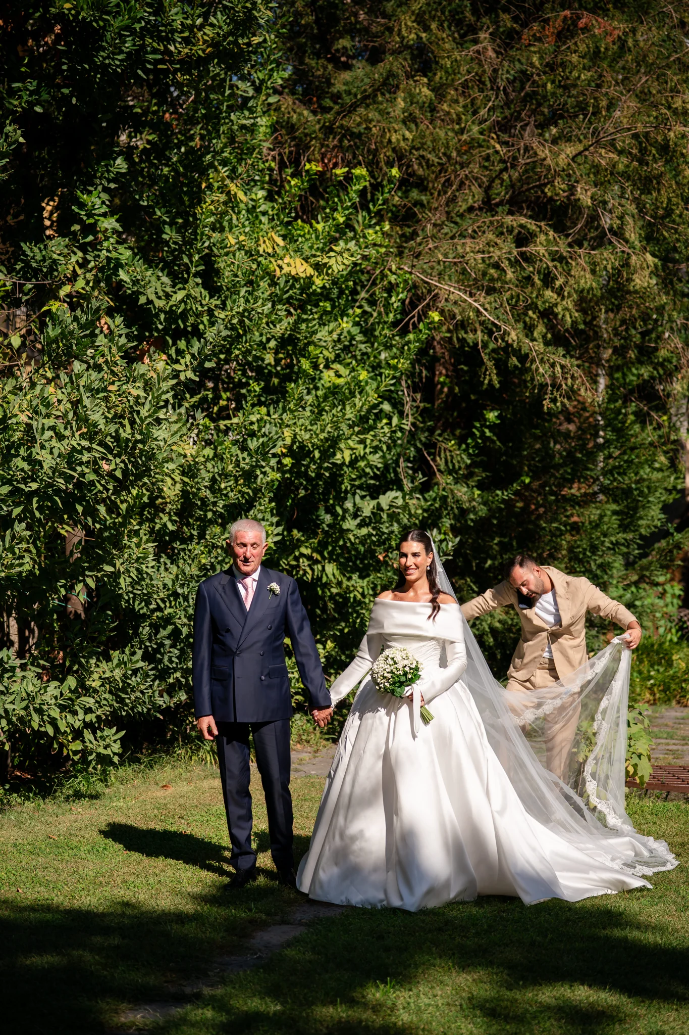 La sposa accompagnata lungo il giardino