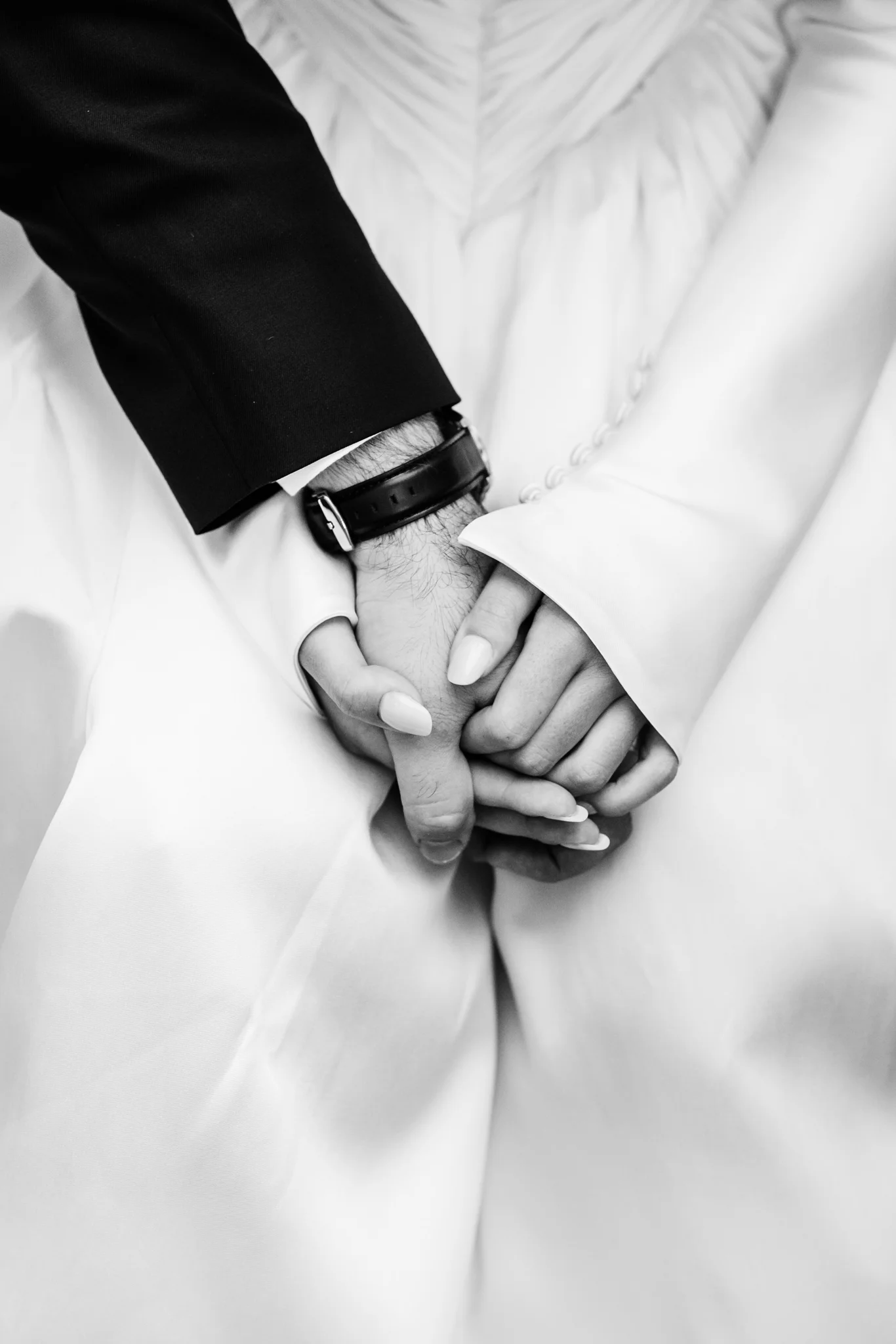 Le fedi e i dettagli dello sposo in bianco e nero
